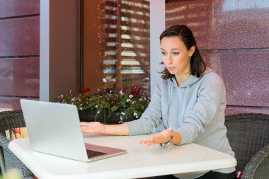 Bir dizüstü bilgisayar kullanarak bir kafede kız