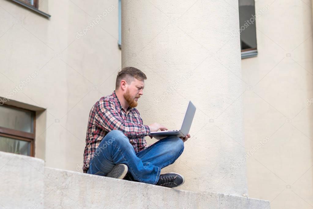 Man sitting on the ledge of the building facade