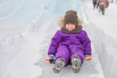 Çocuk buzlu bir tepede haddelenmiş