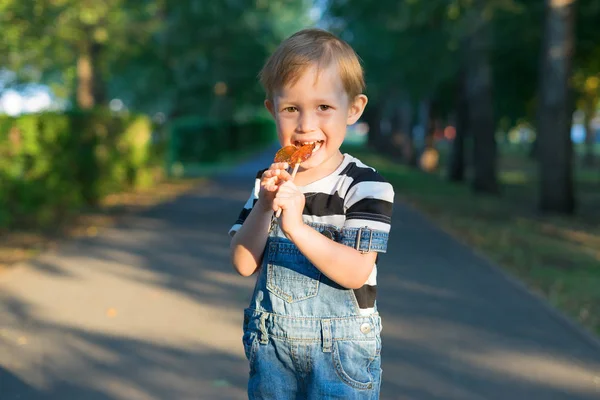 Der Junge nagt an einem Lutscher — Stockfoto