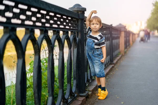 Мальчик опирается на забор — стоковое фото