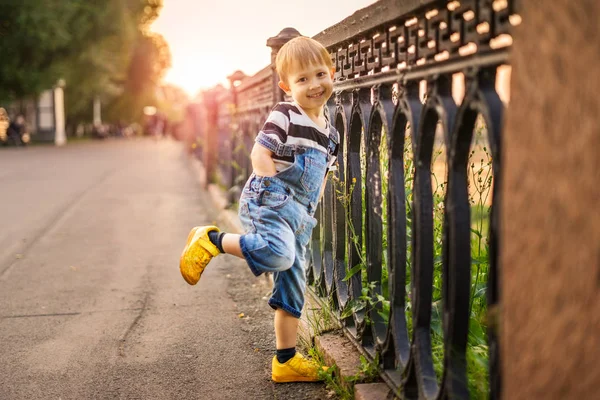 The boy is standing on one leg