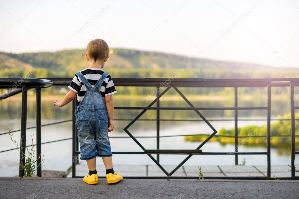 The boy stands on the edge of the ledge