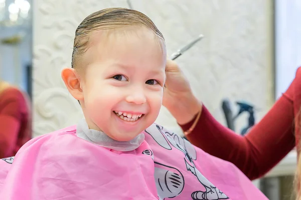 The boy sits in the chair by the hairdresser — Stock Photo, Image