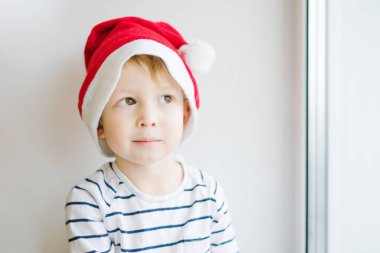 Kırmızı bir Noel Baba şapkalı bir çocuk. 