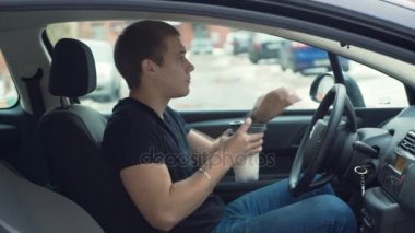 Adam arabanın içinde Protein içeceği içme.