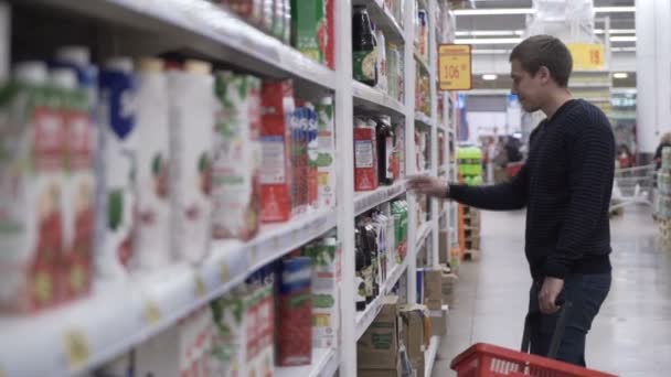 El hombre elige el jugo en el supermercado — Vídeo de stock