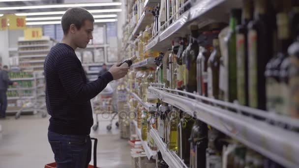 Чоловік вибирає товари в супермаркеті — стокове відео