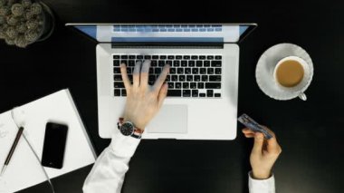 Üstten Görünüm. Online alışveriş için ödeme bir adam laptop ve kredi kartı kullanarak.