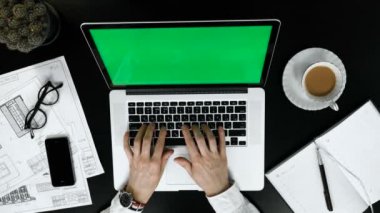 Kahve ile dizüstü bilgisayar üzerinde çalışan adam. Yeşil ekran.