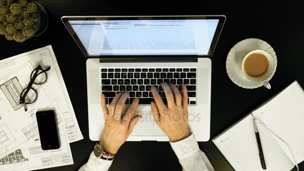 Empresário digitando em seu laptop em uma mesa de madeira. vista superior — Vídeo de Stock