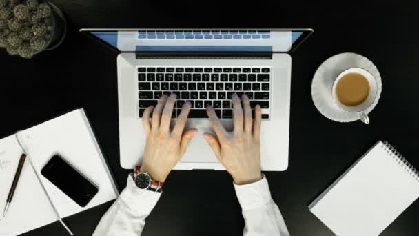 Man working on a wooden table with laptop and drink coffe, top view, — Stock Video