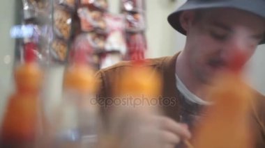 Mutlu genç adam yeme karşılamak ve bira içmek