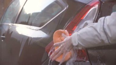 Adam sünger ile yıkayın Otomobil araba Bahçe avlusunda.