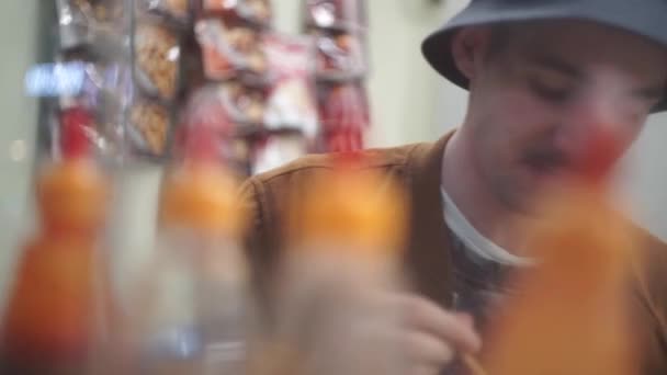 Glücklicher junger Mann isst und trinkt Bier — Stockvideo