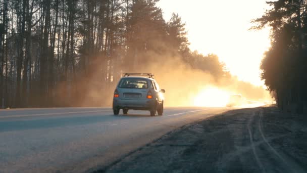 Auto's op de weg met de zonsondergang op de achtergrond. — Stockvideo