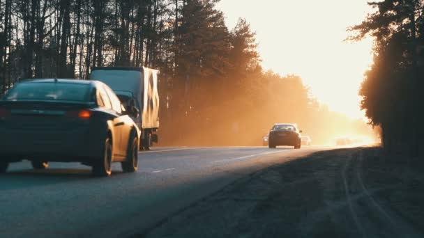 Auto's op de weg met de zonsondergang op de achtergrond. — Stockvideo