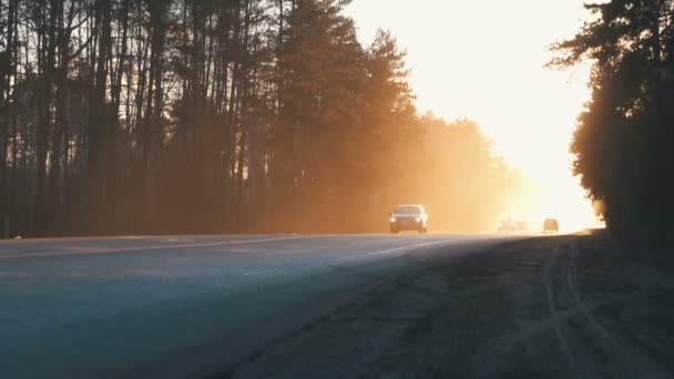 Auto's op de weg met de zonsondergang op de achtergrond. — Stockvideo
