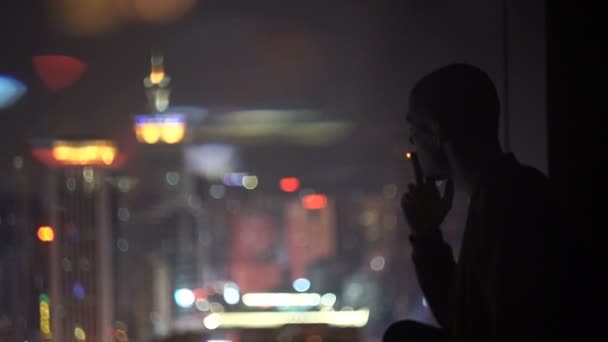Jeune bel homme fumant la cigarette - ville en arrière-plan — Video