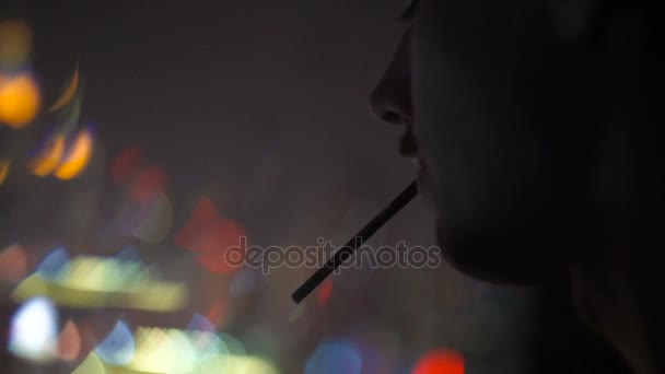 Чоловік на вершині будівлі вночі, дивлячись на місто — стокове відео