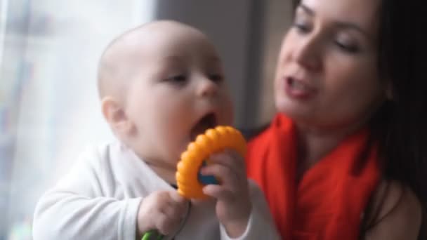 Baby met zijn moeder in de buurt van Donders rammelaar — Stockvideo
