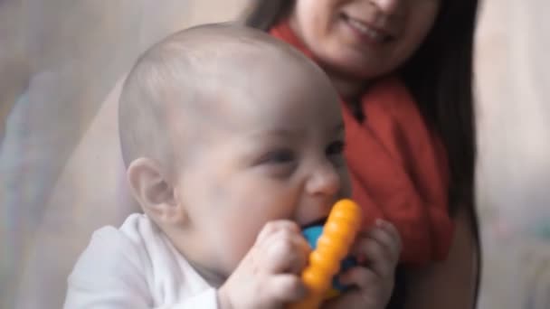 Femme heureuse maman essayer attirer l'attention du bébé avec coloré hochet boîte jouet . — Video