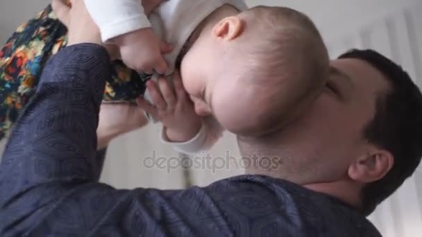 Jovem pai caucasiano carinhosamente segurando bebê bonito enquanto eles brincam juntos — Vídeo de Stock