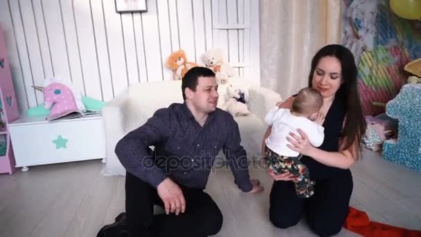 Un jeune père jette un bébé en l'air - Une jeune famille à la fenêtre — Video