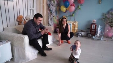 Genç aile 6 aylık bebekle oynarken,