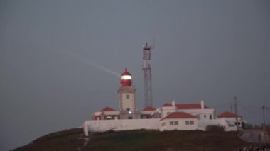 Gün batımından önce çam ormanı yukarıda eski deniz feneri shinning.