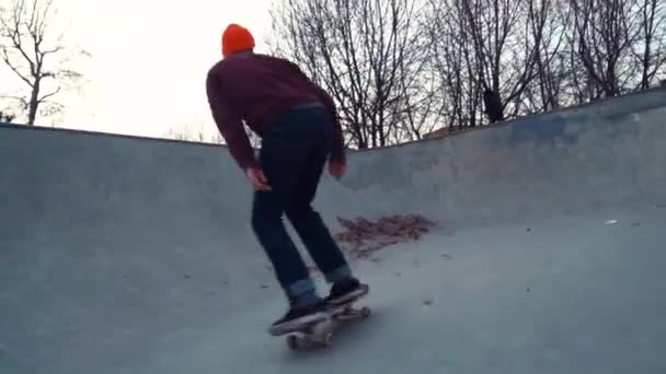 Молодой человек катается на скейтборде в скейтпарке — стоковое видео