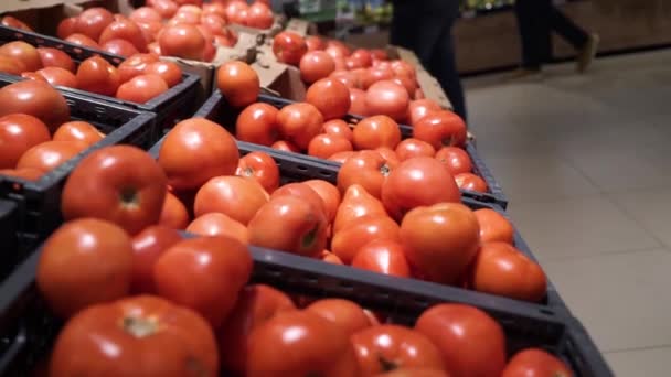 Mujer comprando tomates rojos frescos en el supermercado. Primer plano de las manos de la mujer. Consumismo, venta, concepto orgánico y sanitario — Vídeos de Stock