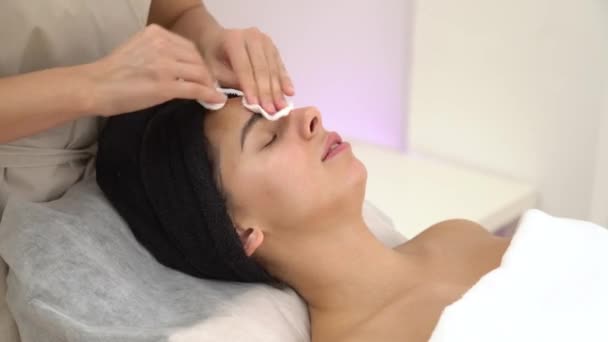 Masaż twarzy kobiety ze spa. Masaż twarzy w salonie spa. Kobieta korzystająca relaksujący masaż twarzy w centrum spa kosmetologii. — Wideo stockowe