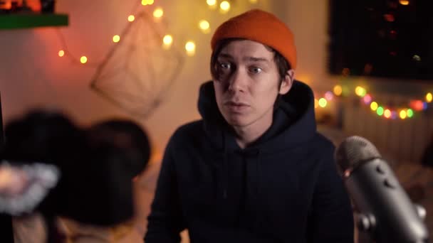 Moderní hipster muž v oranžové čepici nahrává video blog o objektivech. Lifestyle video blog. — Stock video