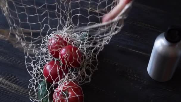 Herbruikbare boodschappentassen met groenten en fruit, herbruikbare waterfles op de keuken op zwarte houten tafel. Geen afval thuis — Stockvideo