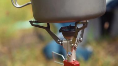 Kampanyadaki dağcı yemek pişirmek için gaz ocağı kuruyor.