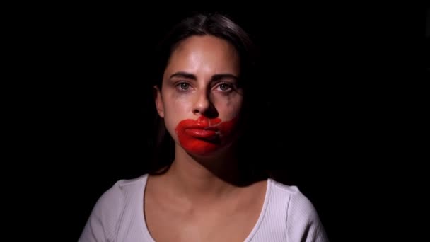 Arrêtez la violence domestique. Une fille triste larmoyante et effrayée regardant dans la caméra sur fond noir. Violence domestique et problèmes sociaux concept — Video