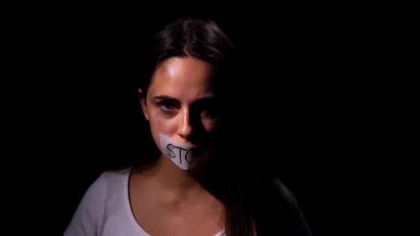 가정폭력을 막는다. 까만 배경의 카메라를 보면서 눈물을 글썽 이며 두려워하는 한 소녀가 보였다. 가정폭력 과 사회 문제 개념 — 비디오