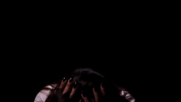 A tearful and frightened sad girl looking in the camera on black background. Domestic violence and social problems concept — Stockvideo