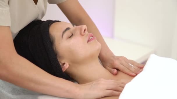 Masaż twarzy kobiety ze spa. Masaż twarzy w salonie spa. Kobieta korzystająca relaksujący masaż twarzy w centrum spa kosmetologii. — Wideo stockowe