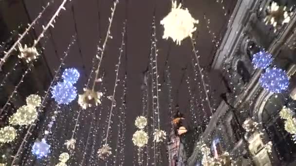 Vista desenfocada de los peatones caminando por la calle bellamente decorada para las vacaciones de Navidad de invierno hacia el árbol de Navidad más grande de Europa. Moscú Rusia — Vídeos de Stock