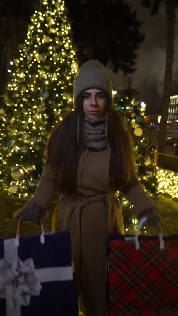 Kerst boodschappentas kerst achtergrond kerstboom. . Vrouw geniet van de Europese kerstmarkt met boodschappentassen. Winkelen meisje stading winter stad straat achtergrond kerstboom. — Stockvideo