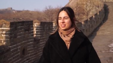 Mutlu kadın Çin Seddi 'nde yürüyor, kışın gün batımında Badaling bölümündeki gözetleme kulesinden iniyor.