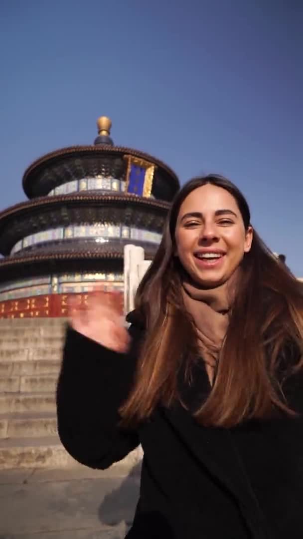 Красива жінка подорожує Азією, стоїть на небесному храмі в Пекіні і під час відпустки робить селфі чи відеозйомку. Щаслива молода жінка подорожує самовіддано в храмі небесному — стокове відео