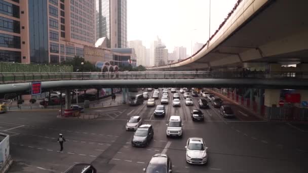 Shanghai, China ENERO 3 2020.: Tráfico pesado en el cruce de la carretera a través del centro de la ciudad. Rascacielos la gente camina en el puente — Vídeos de Stock