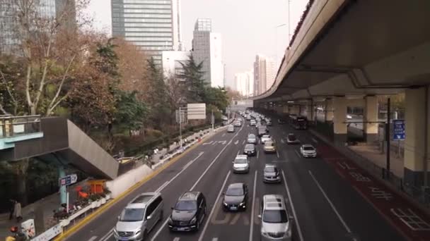 Shanghai, China JANEIRO 3 2020.: Tráfego pesado na encruzilhada da Estrada através do centro da cidade. Arranha-céus as pessoas caminham na ponte — Vídeo de Stock