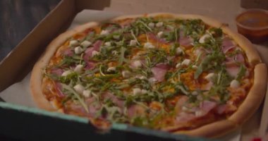 Yetenekli İtalyan şef, üzerinde taze fesleğen yaprakları olan lezzetli geleneksel mozzarella pizzası servis ediyor. 4K 'da yakın çekim.