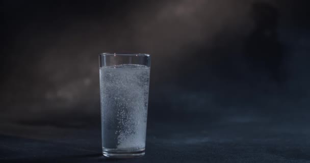 La píldora cayendo al agua sobre fondo negro. Una tableta soluble cayó en el agua. Medicina, atención médica, concepto de tratamiento — Vídeo de stock