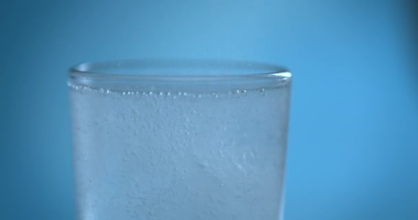 Effervescent aspirine tablet laten vallen op glas water, close-up slow motion fizzy pil valt en lost op met bellen. Geneeskunde, farmaceutisch concept voor de gezondheidszorg — Stockvideo