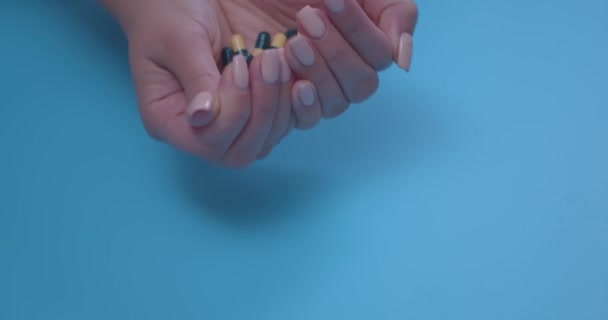 Close-up van een vrouwenhanden met een handvol pillen. Het concept van gezondheid, medicijnen en anticonceptie. Coronavirus behandeling concept. Gezondheidszorgconcept. Farmaceutische industrie. — Stockvideo